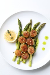 Delicious fried scallops with asparagus, lemon and thyme on white background, top view