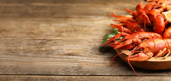 Image of Delicious red boiled crayfishes on table, space for text. Banner design