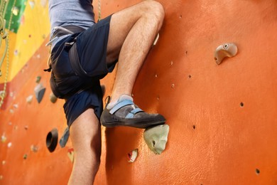 Image of Athletic man climbing wall in gym, closeup