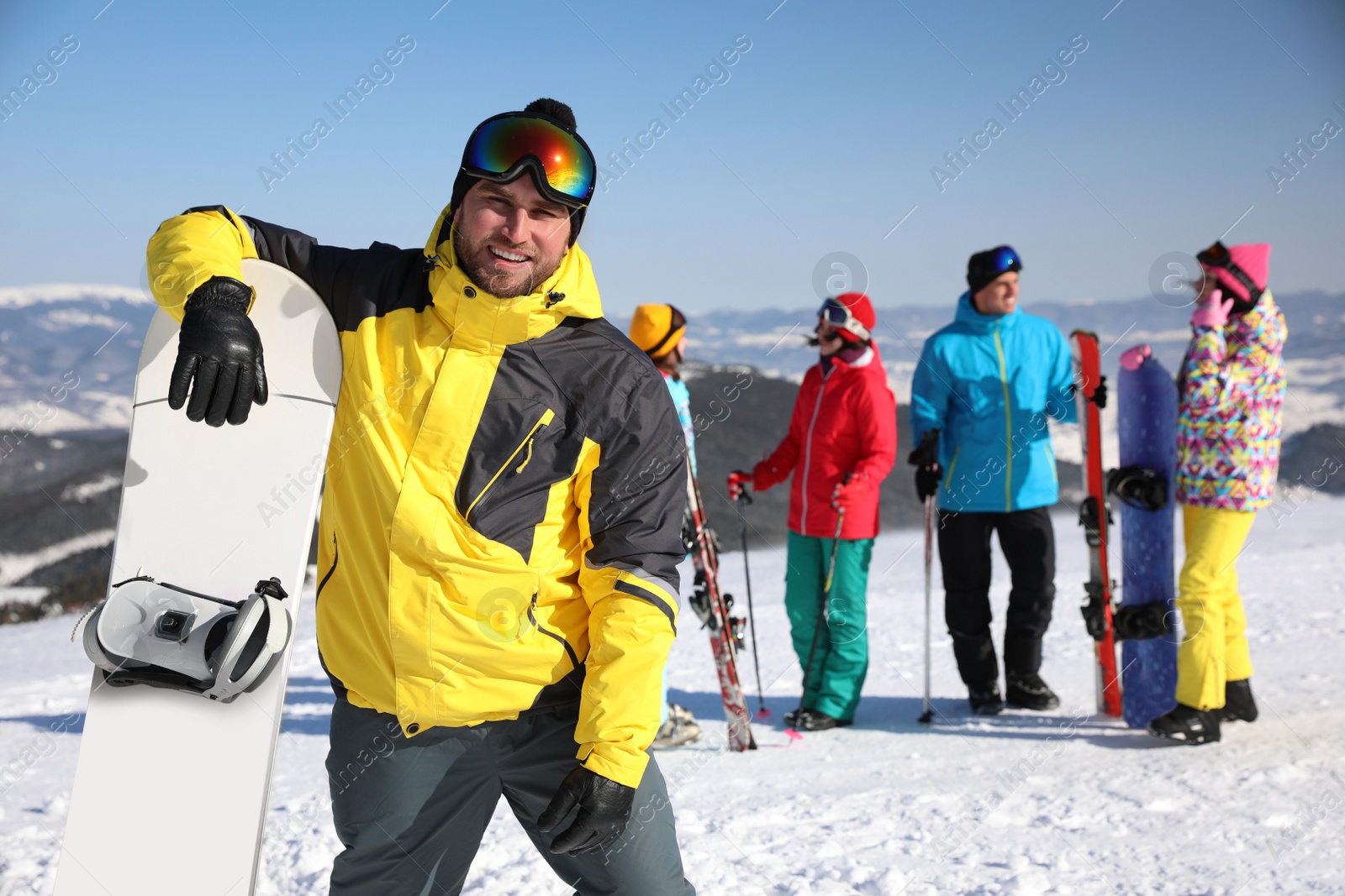 Photo of Young man with snowboard at ski resort. Winter vacation