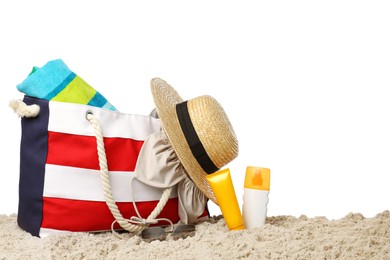 Stylish bag with beach accessories on sand against white background