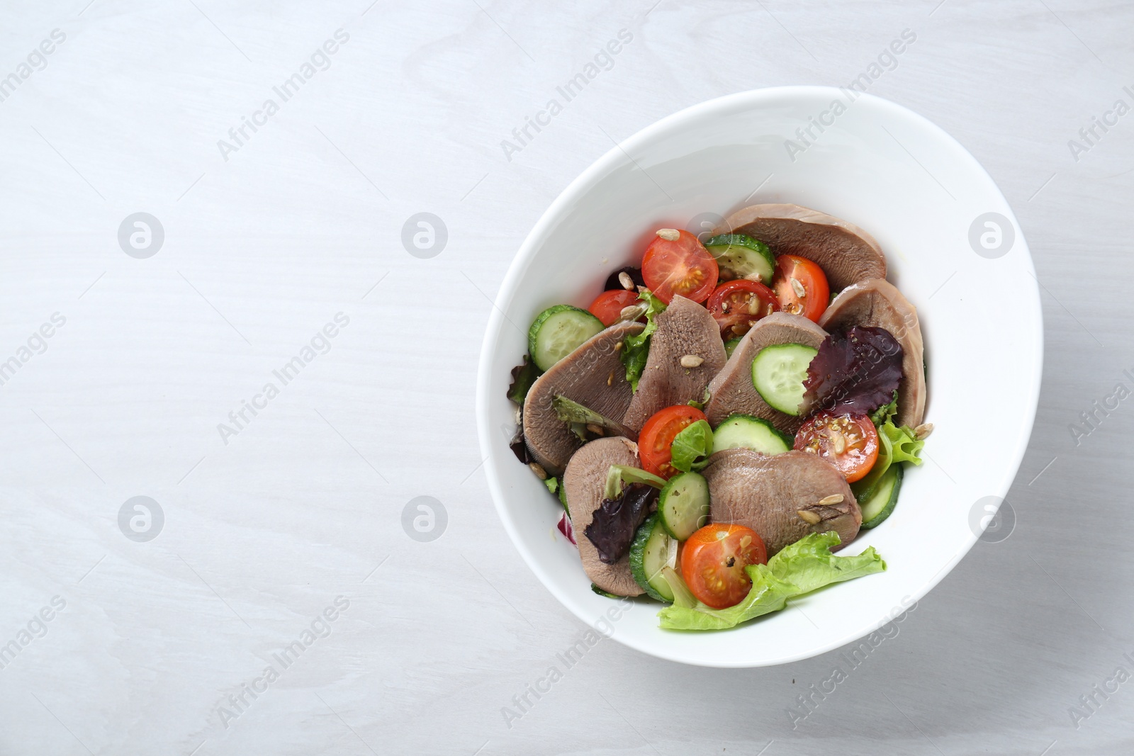 Photo of Delicious salad with beef tongue and vegetables on white wooden table, top view. Space for text