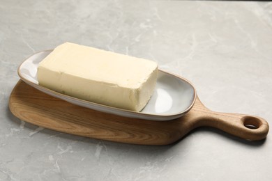 Block of tasty butter on grey table