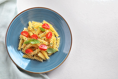 Delicious pasta with tomatoes and basil on white table, top view