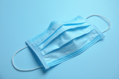 Photo of Medical face mask on blue background, closeup