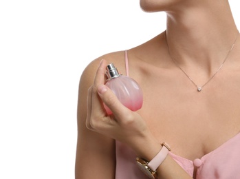 Photo of Young woman spraying perfume onto skin against white background, closeup