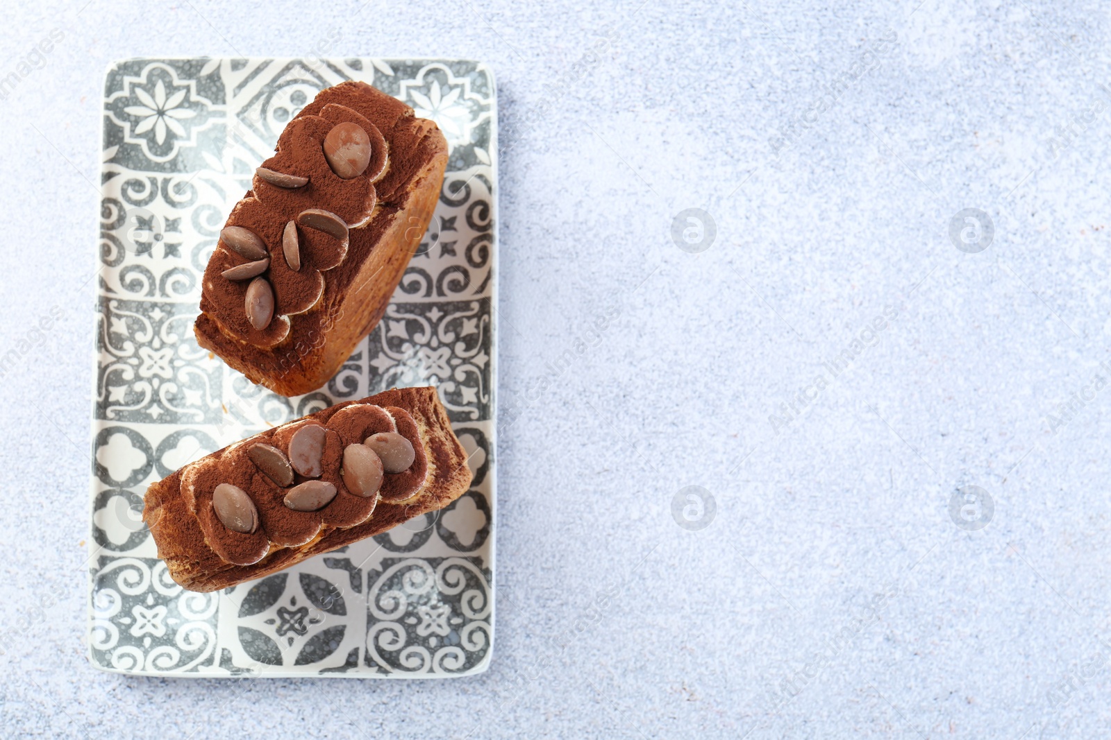 Photo of Tasty puff pastry. Supreme croissants with chocolate chips and cream on grey table, top view. Space for text