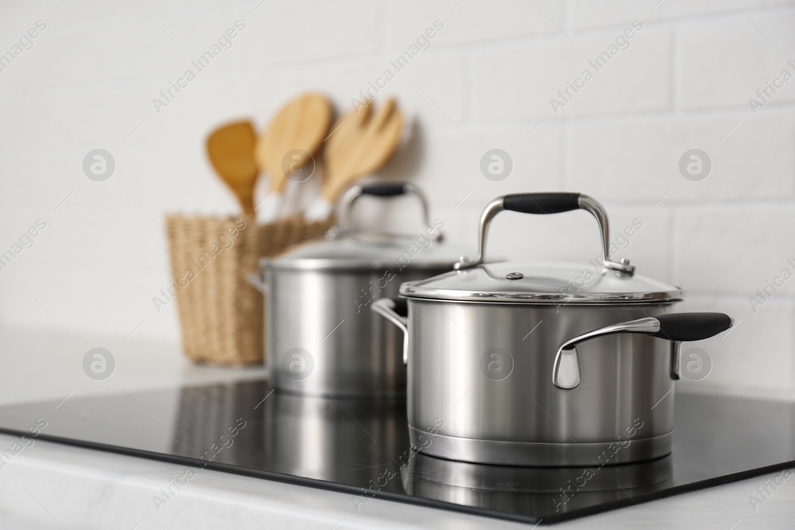 Photo of New saucepots on induction stove in kitchen