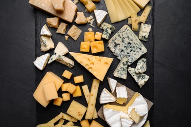 Photo of Cheese plate on black table, top view