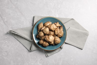 Photo of Jerusalem artichokes on light grey marble table, top view
