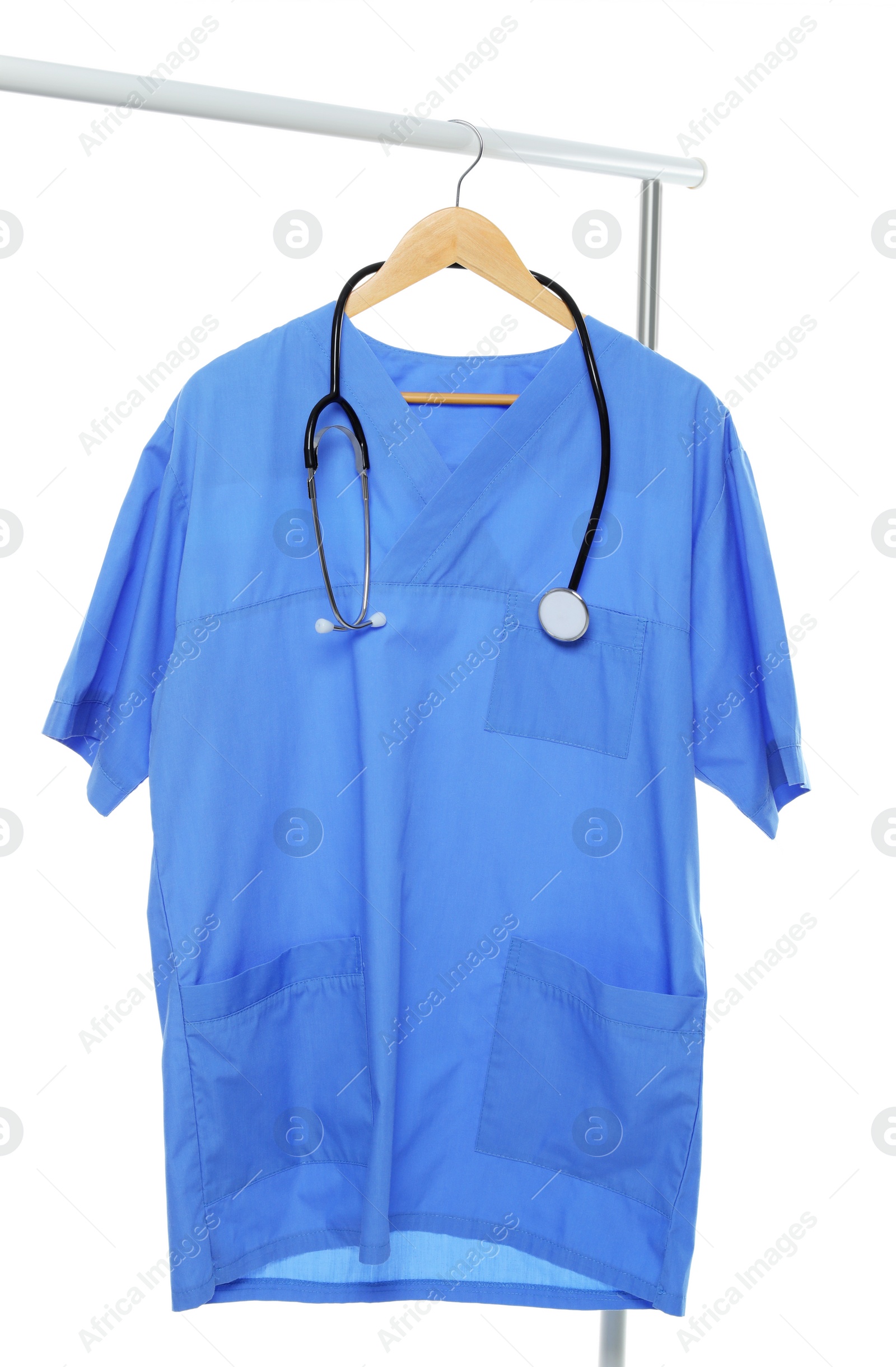 Photo of Light blue medical uniform and stethoscope on rack against white background