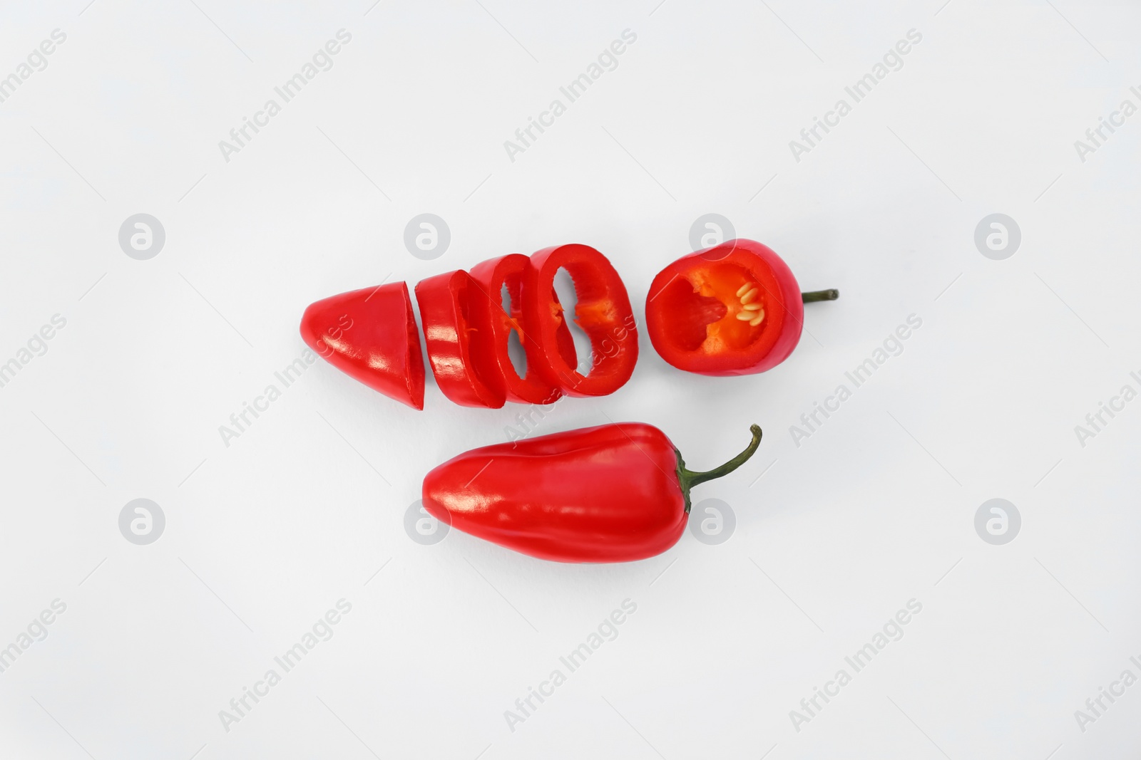 Photo of Whole and cut red hot chili peppers on white background, flat lay