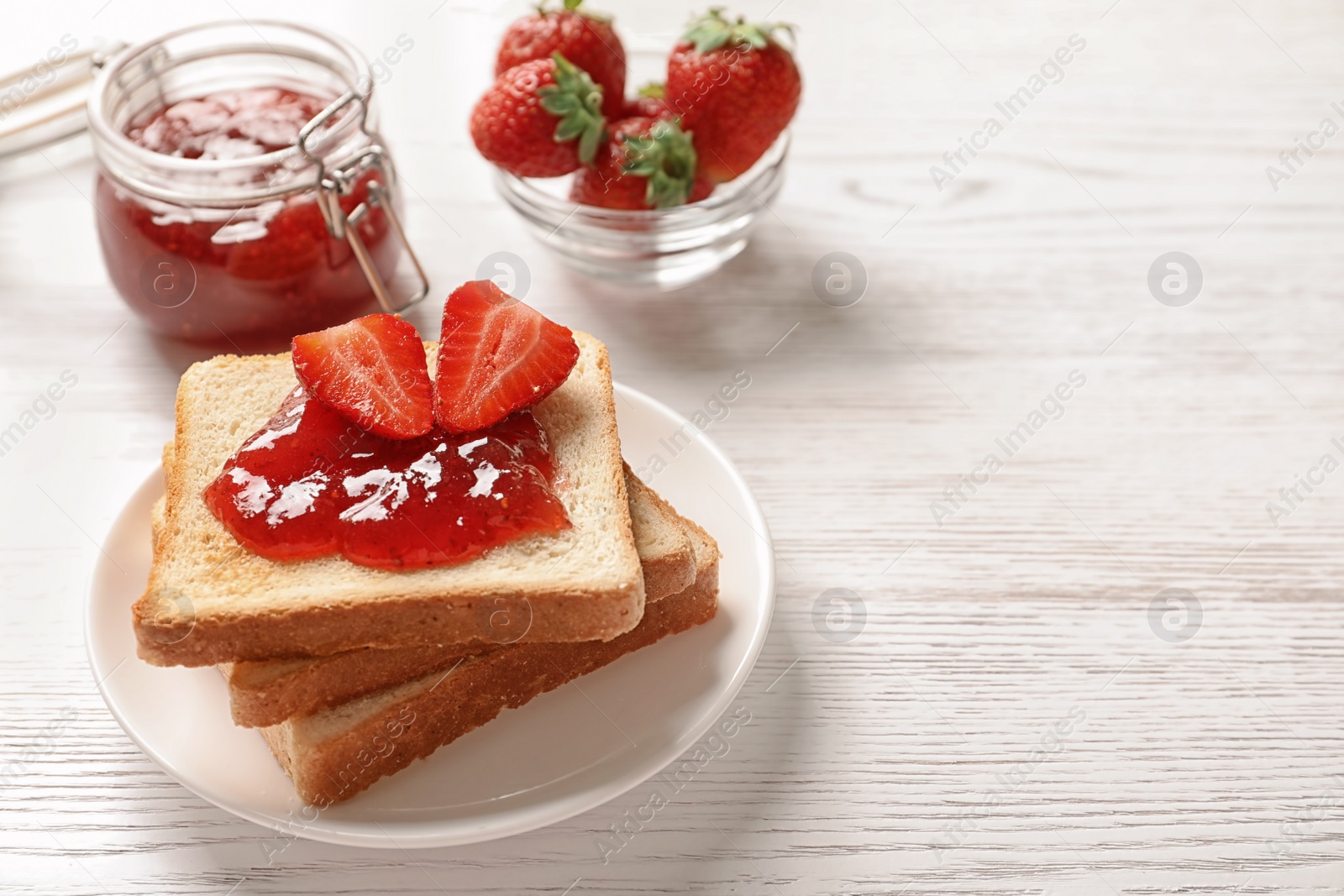 Photo of Tasty toast bread with strawberry jam and fresh berries on light background