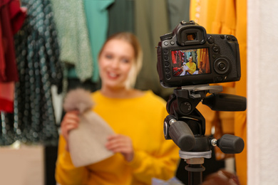 Photo of Fashion blogger recording new video in wardrobe, focus on camera