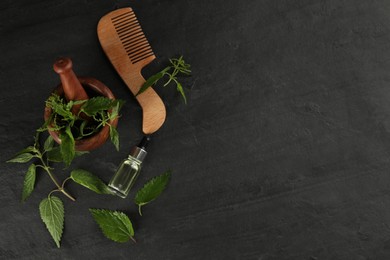 Photo of Stinging nettle leaves, extract and comb on black background, flat lay with space for text. Natural hair care