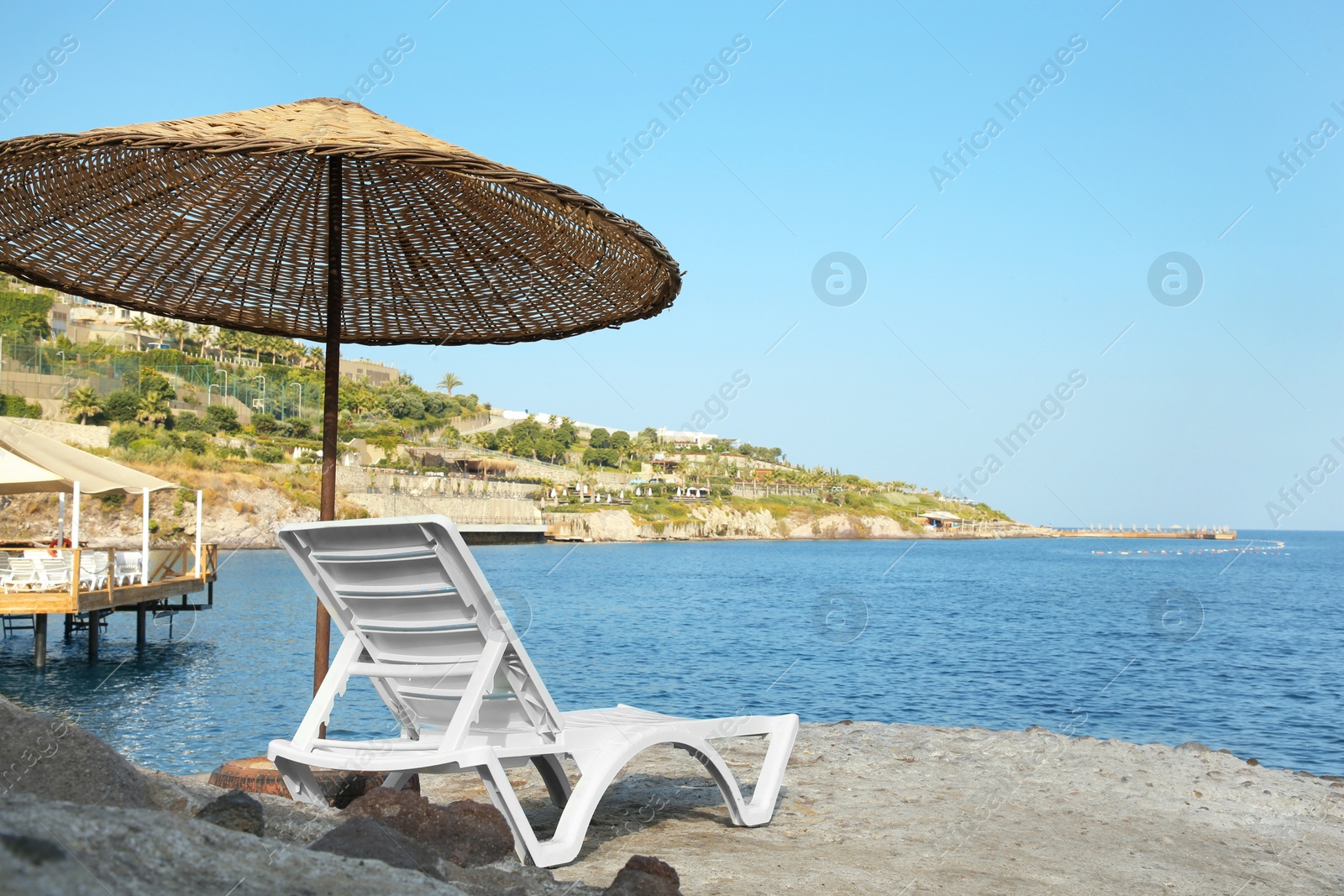 Photo of Lounge chair and beach umbrella on sea shore