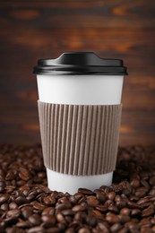 Photo of Coffee to go. Paper cup and roasted beans against wooden background