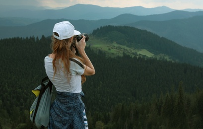 Photo of Professional nature photographer taking pictures in mountains. Space for text