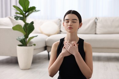 Photo of Beautiful girl meditating at home. Practicing yoga