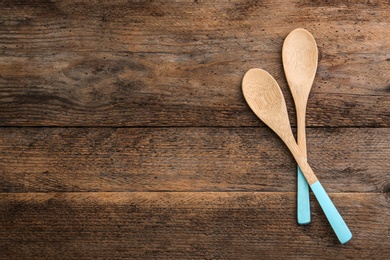 Clean empty bamboo spoons on wooden background, top view. Space for text