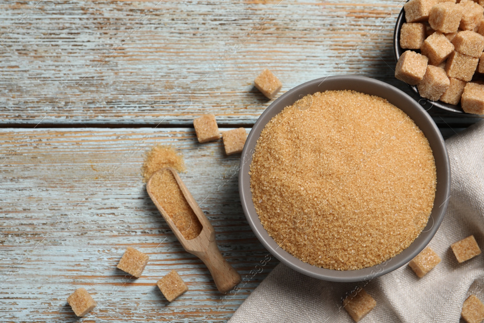 Photo of Granulated and refined sugar on rustic table, flat lay. Space for text