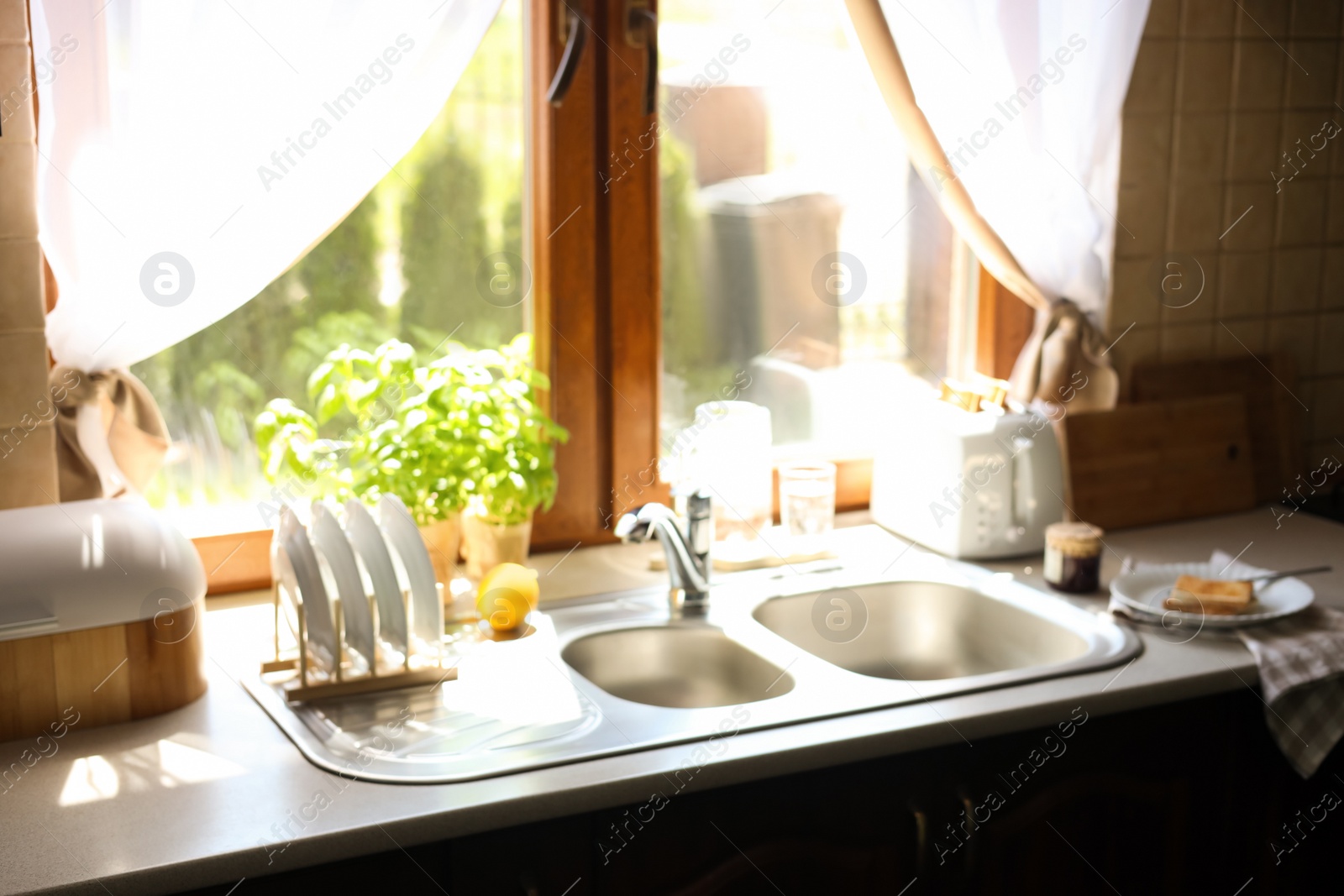 Photo of Blurred view of stylish kitchen interior with sink and food