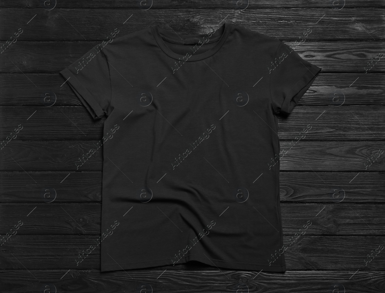 Photo of Stylish t-shirt on black wooden background, top view