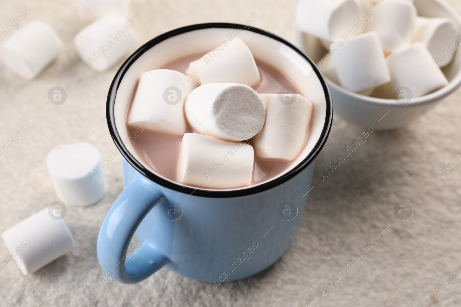 Photo of Cup of aromatic hot chocolate with marshmallows on beige table, closeup