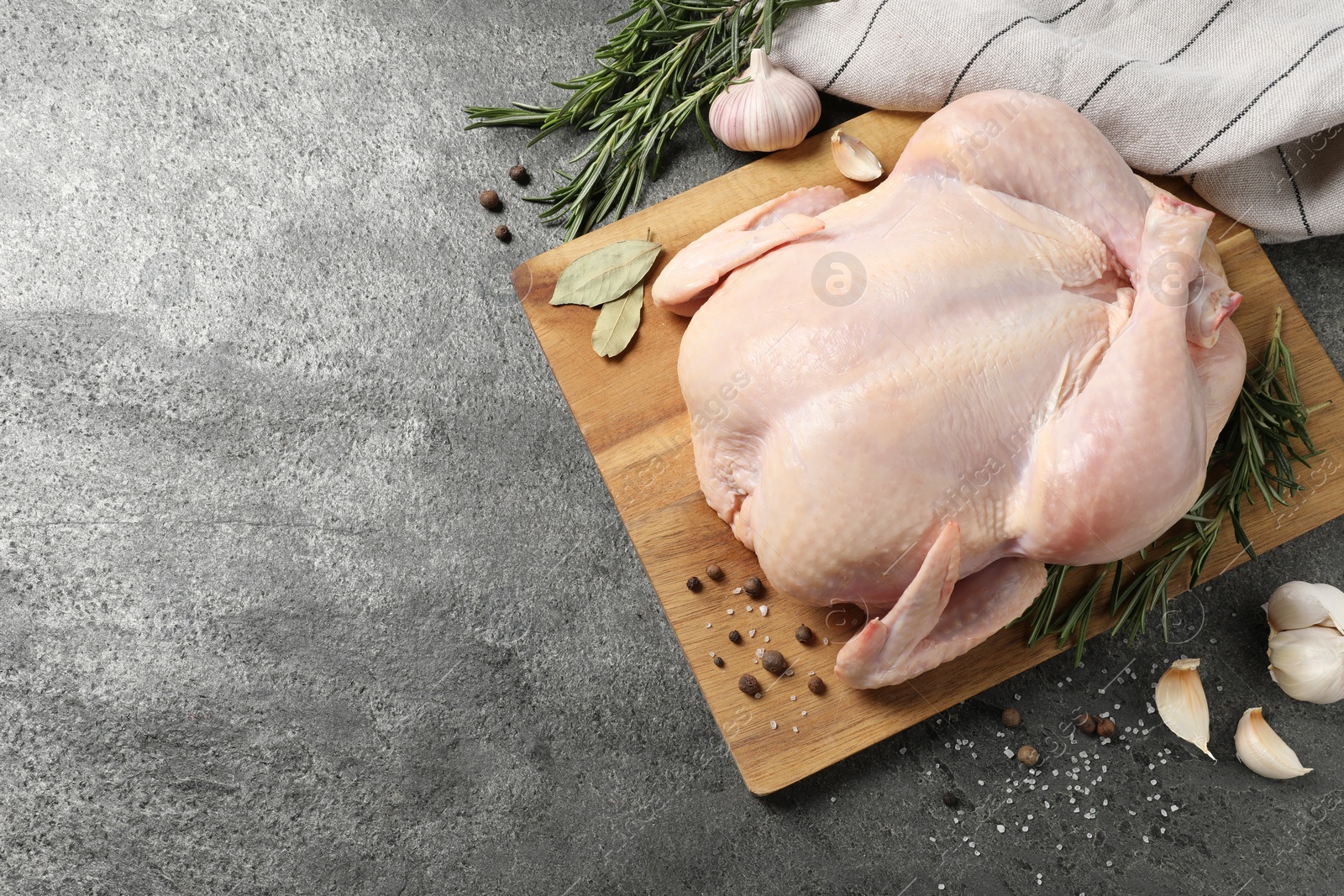 Photo of Fresh raw chicken with spices on grey textured table, flat lay. Space for text