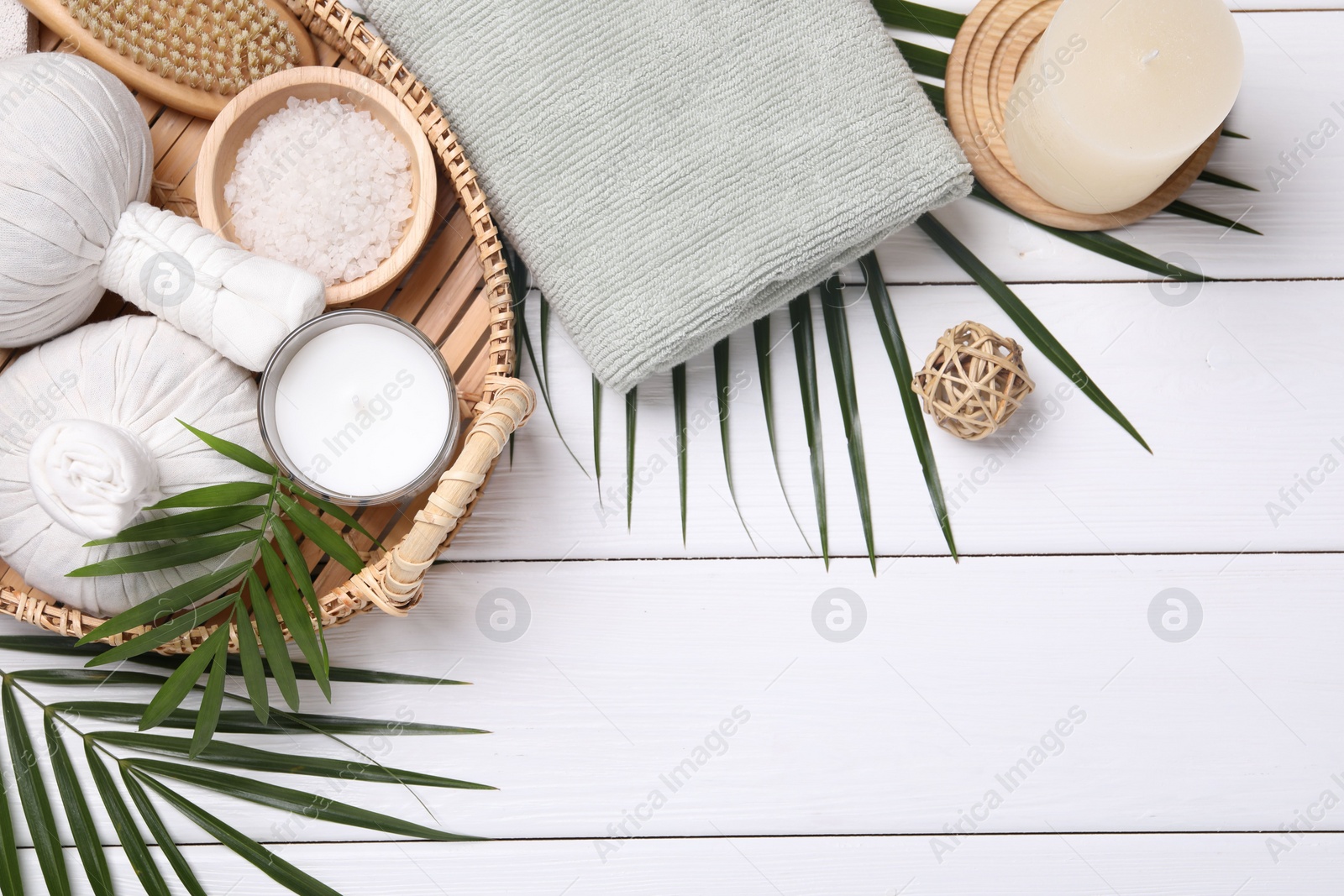 Photo of Flat lay composition with candle and different spa products on white wooden table. Space for text