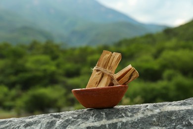 Many palo santo sticks on stone surface outdoors