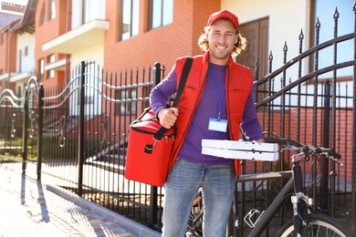 Male courier delivering food in city on sunny day