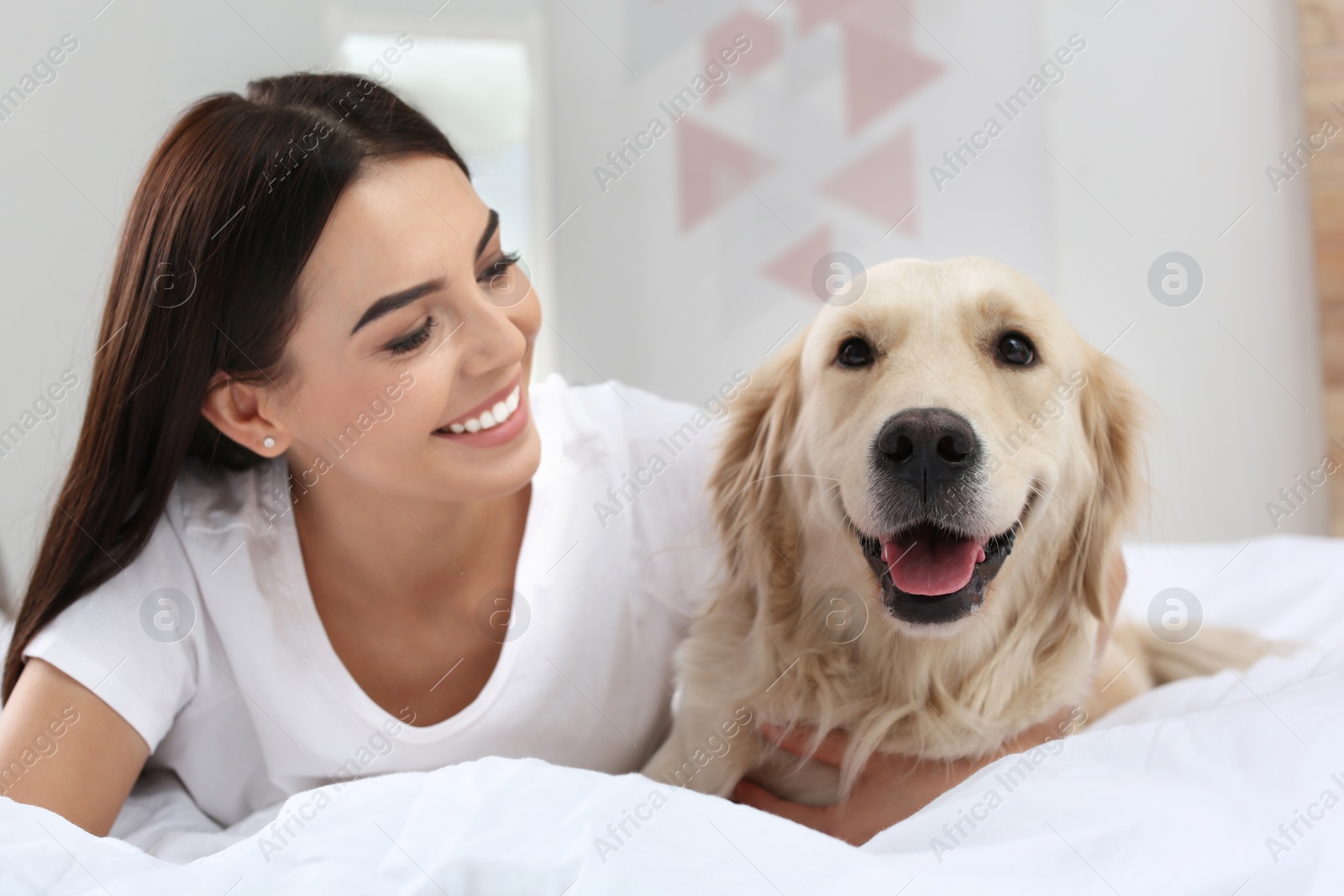 Image of Happy woman with her cute pet dog at home