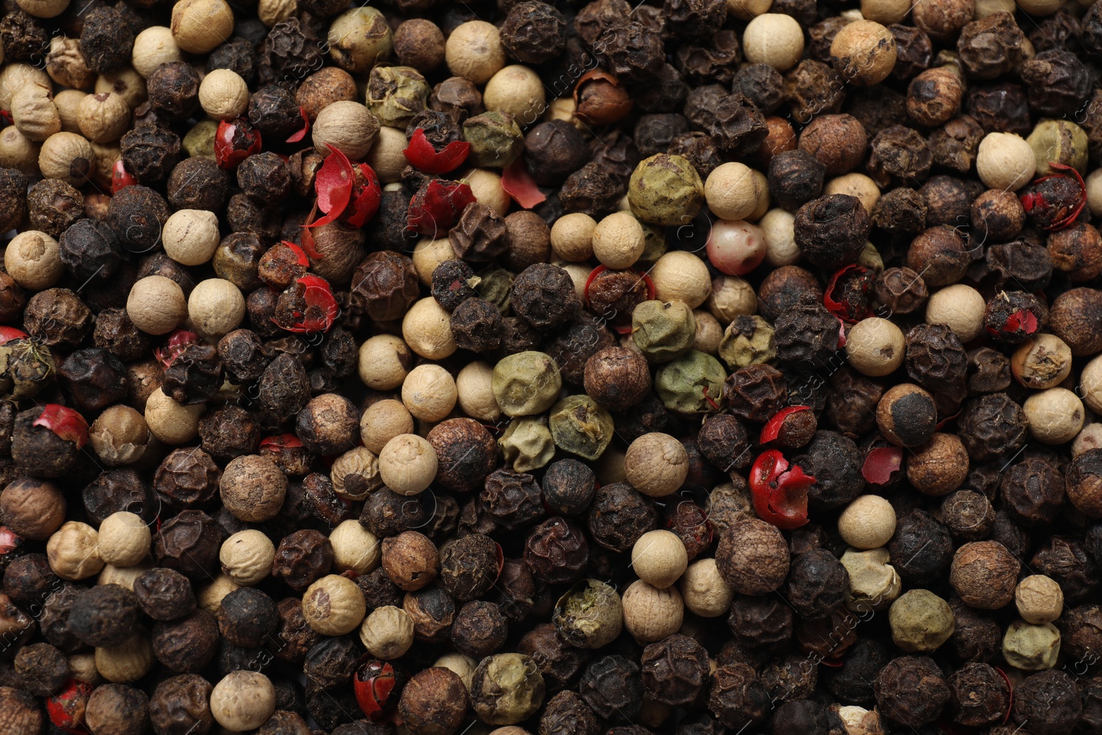 Photo of Aromatic spices. Different peppers as background, top view