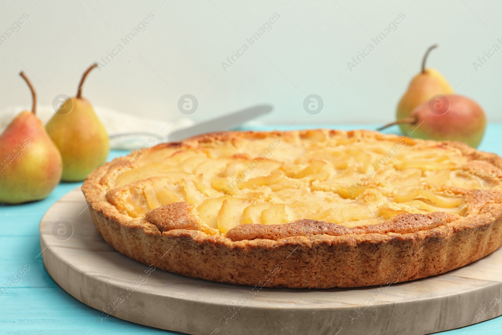 Photo of Delicious sweet pear tart on light blue wooden table