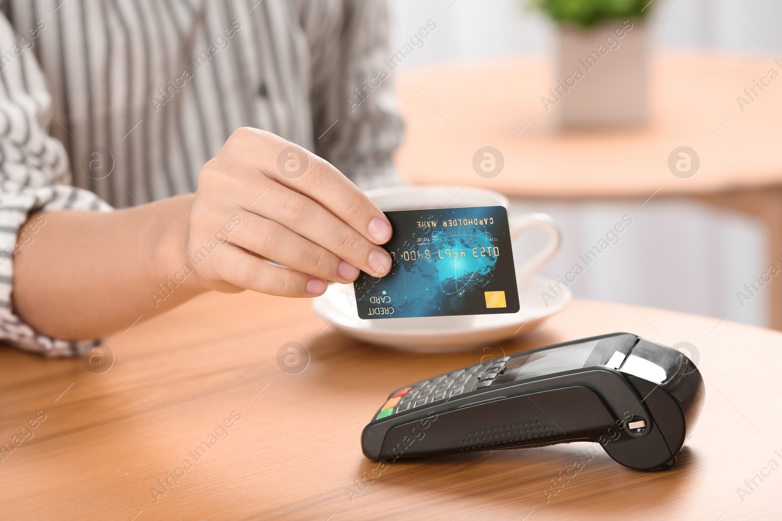 Photo of Woman using terminal for credit card payment in cafe