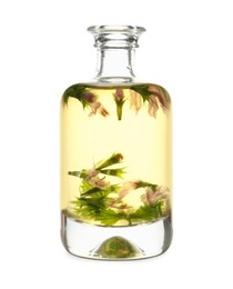 Glass bottle of nettle oil with flowers on white background