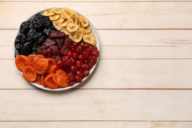 Delicious dried fruits on white wooden table, top view. Space for text