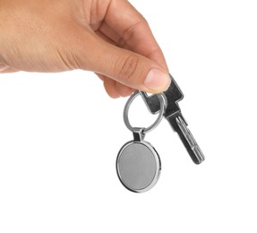 Woman holding key with metallic keychain on white background, closeup