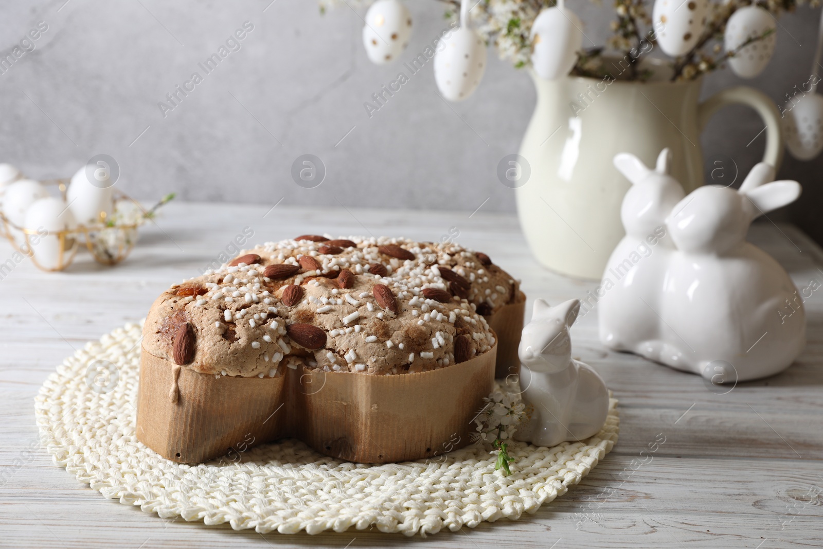 Photo of Delicious Italian Easter dove cake (Colomba di Pasqua) and festive decor on white wooden table