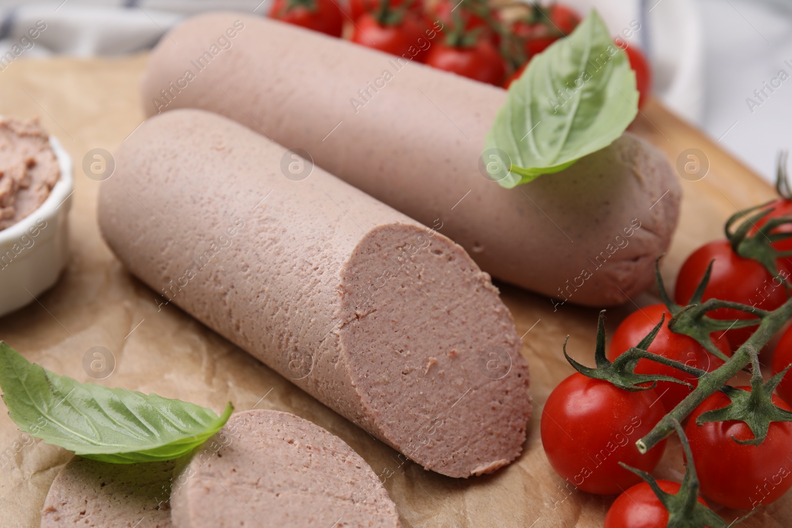 Photo of Delicious liver sausages and cherry tomatoes on table, closeup