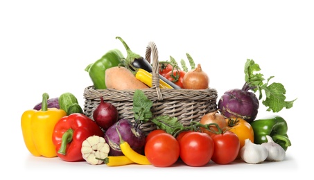 Photo of Many fresh ripe vegetables with basket on white background