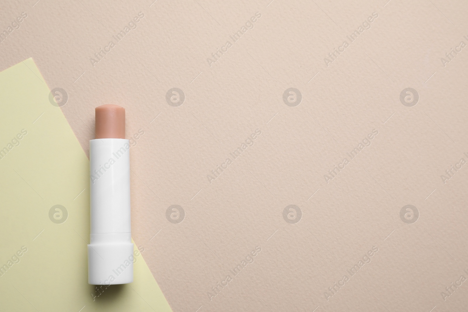 Photo of Hygienic lipstick on color background, top view. Space for text