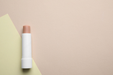 Photo of Hygienic lipstick on color background, top view. Space for text