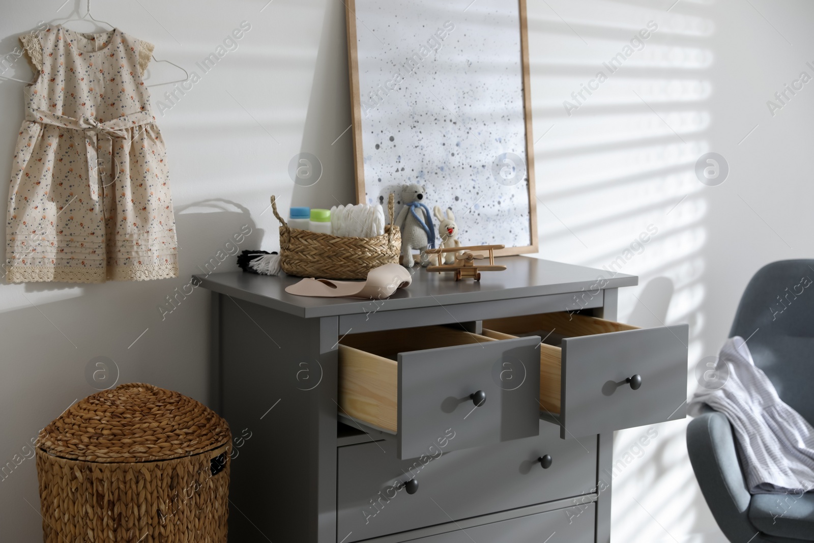 Photo of Stylish chest of drawers and accessories in child room