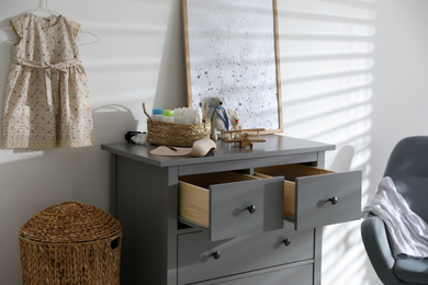 Photo of Stylish chest of drawers and accessories in child room