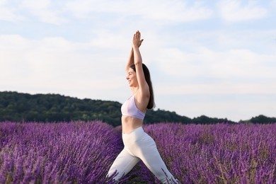 Photo of Happy woman practicing yoga in lavender field