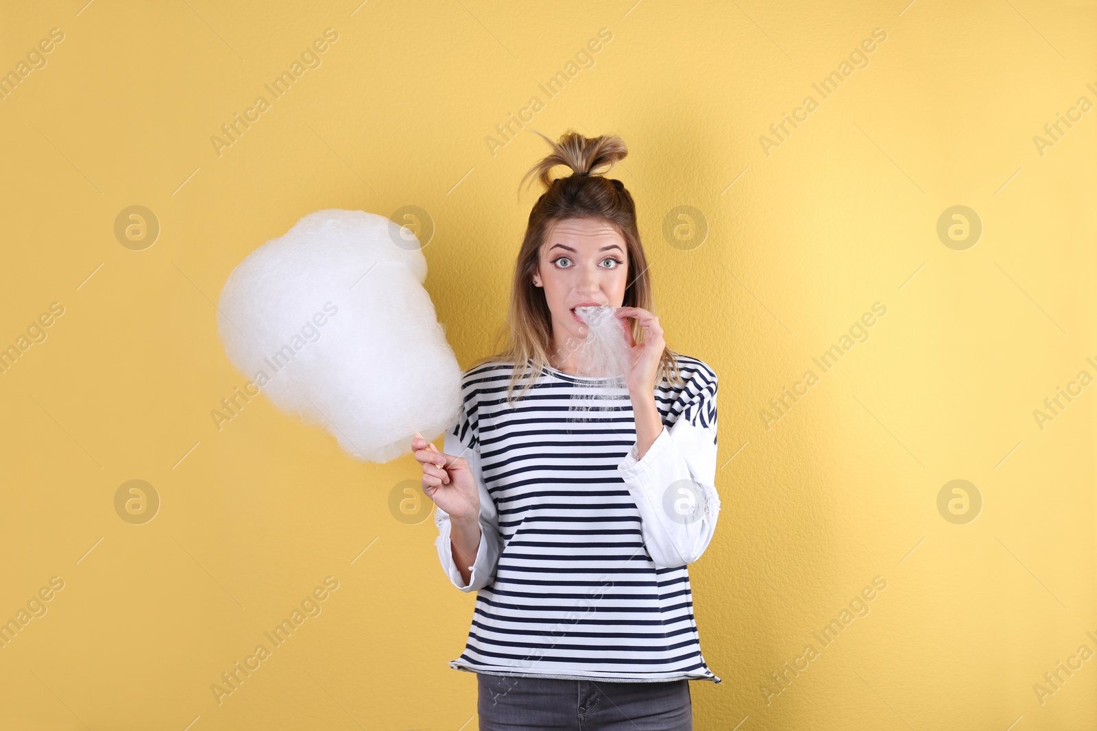 Photo of Young pretty woman with cotton candy on colorful background