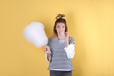 Photo of Young pretty woman with cotton candy on colorful background
