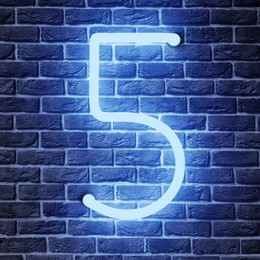 Image of Glowing neon number 5 sign on brick wall